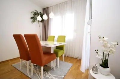 a dining room with a table and four chairs at Comfort Residence Art Zone in Podgorica