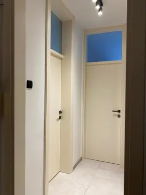 an empty hallway with a door and a window at Original Sunny place in Podgorica