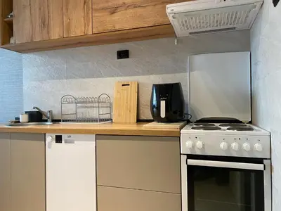 a kitchen counter with a stove and a microwave at Original Sunny place in Podgorica