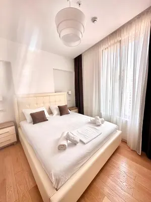 a bedroom with a white bed with a large window at Apartman Drobnjak Center-sea View in Budva