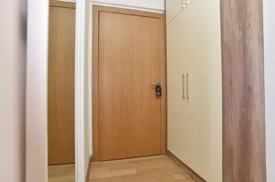 a corridor with a wooden door in a room at Apartman Drobnjak Center-sea View in Budva