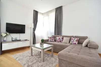 a living room with a couch and a tv at Apartman Drobnjak Center-sea View in Budva