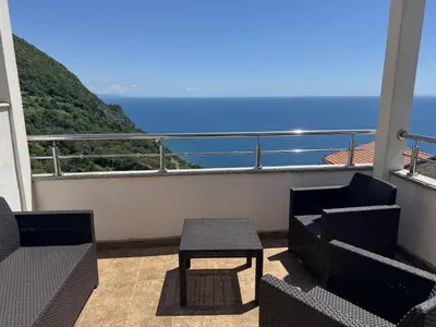 a balcony with chairs and a table and the ocean at Villa Happy Family!!! in Prijevor