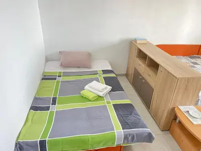 a small bedroom with a bed and a wooden cabinet at Villa Happy Family!!! in Prijevor