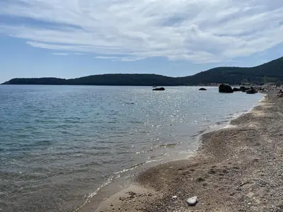 a beach with a rocky shore and the ocean at Villa Happy Family!!! in Prijevor