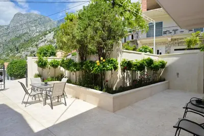a patio with a table and chairs and a fence at Sapphire view apartment in Kotor