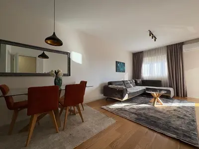 a living room with a table and a couch at Apartments Central Point 11 & Private Garage in Podgorica