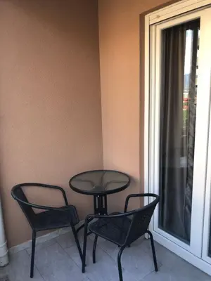 a table and two chairs sitting next to a window at Apartments Central Point 11 & Private Garage in Podgorica