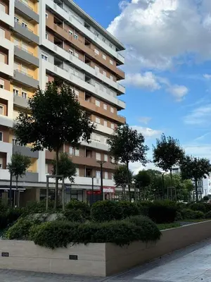 a large apartment building with trees in front of it at Apartments Central Point 11 & Private Garage in Podgorica