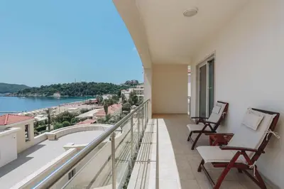a balcony with chairs and a view of the water at The Unique Splendid Conference Spa Resort Family apt suite sleeps 6 in Becici