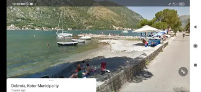 a group of people on a beach with boats in the water at MD Residence in Kotor