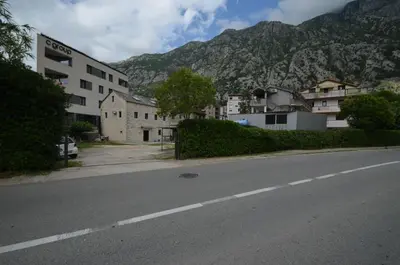 an empty street with a building and a mountain at MD Residence in Kotor