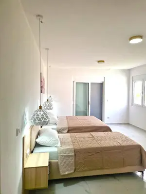 a bedroom with a large bed and a table at IVANA Apartments in Ulcinj