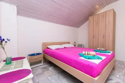 a bedroom with a large bed with a pink bedspread at Apartment Carpe Diem with the best sea view, Utjeha Montenegro Mediterranean Eu in Masline