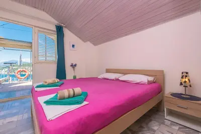 a bedroom with a large pink bed with a window at Apartment Carpe Diem with the best sea view, Utjeha Montenegro Mediterranean Eu in Masline