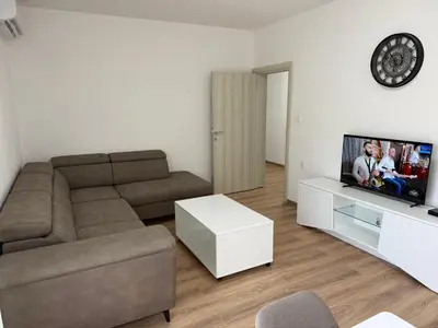 a living room with a couch and a flat screen tv at Dane Apartment Airport Podgorica in Mitrovići