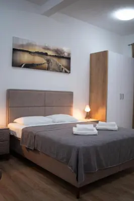 a bedroom with a bed with two towels on it at Dane Apartment Airport Podgorica in Mitrovići