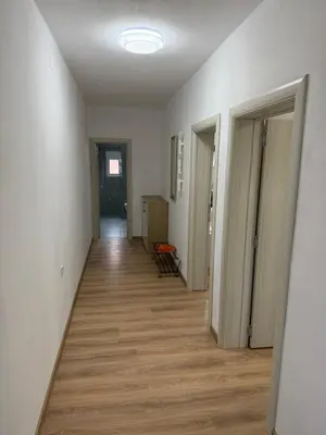 an empty hallway with white walls and wooden floors at Dane Apartment Airport Podgorica in Mitrovići