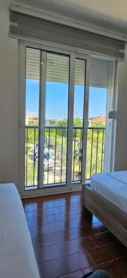 a bedroom with a view of a balcony with two beds at KenDar Premium Apartments in Ulcinj