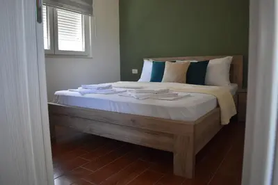 a bedroom with a large bed with a window at KenDar Premium Apartments in Ulcinj
