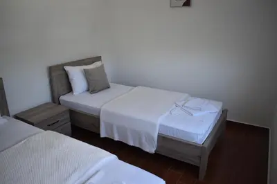two beds in a room with white sheets at KenDar Premium Apartments in Ulcinj