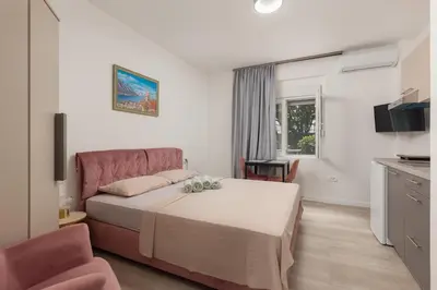 a hotel room with a bed and a kitchen at Apartments TIME in Kotor