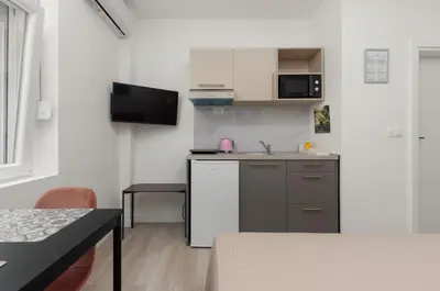 a small kitchen with a sink and a refrigerator at Apartments TIME in Kotor