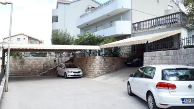 two cars parked in a parking lot next to a building at Apartments TIME in Kotor