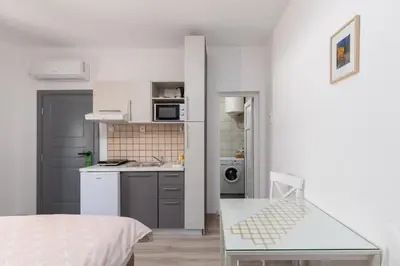 a small kitchen with a sink and a table at Apartments TIME in Kotor