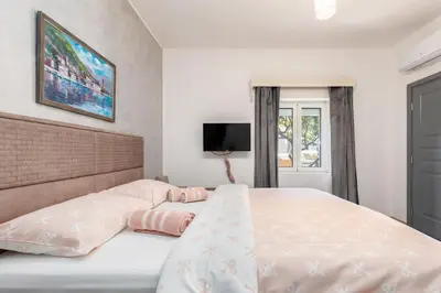 a bedroom with a large bed with pink pillows at Apartments TIME in Kotor