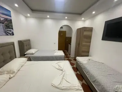 a room with two beds and a flat screen tv at Kodra Apartments in Ulcinj
