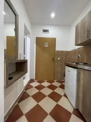 a kitchen with a checkered floor and a wooden door at Kodra Apartments in Ulcinj