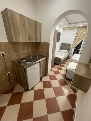 a kitchen with a stove and a checkered floor at Kodra Apartments in Ulcinj