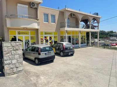 two cars parked in a parking lot in front of a building at Kodra Apartments in Ulcinj