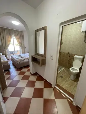a room with a bathroom with a toilet and a bed at Kodra Apartments in Ulcinj