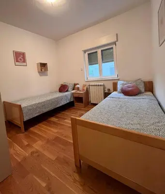 a bedroom with two beds and a window at Sunny apartments in Budva