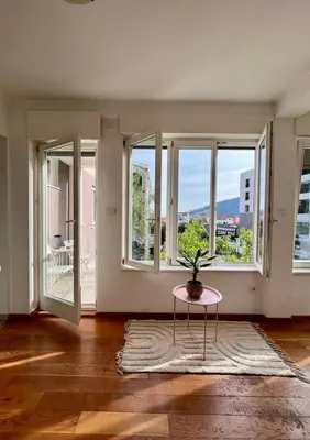 an empty living room with a table and windows at Sunny apartments in Budva