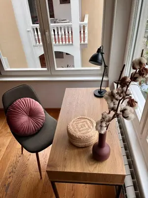 a room with a table with a vase and a chair at Sunny apartments in Budva