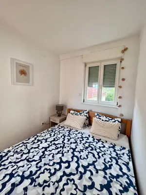 a bedroom with a blue and white bed with two pillows at Sunny apartments in Budva