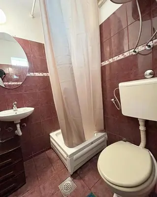 a bathroom with a toilet and a shower and a sink at Zinzula apartments in Bar