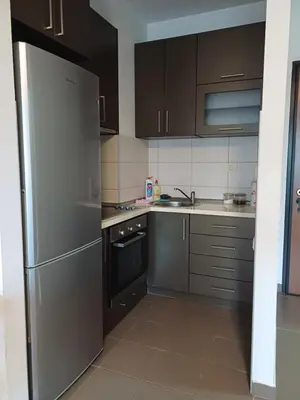 a kitchen with stainless steel appliances and brown cabinets at Apartman City kvart pg in Podgorica