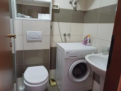 a small bathroom with a washing machine and a sink at Apartman City kvart pg in Podgorica