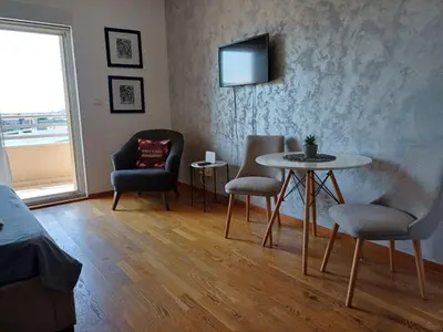 a living room with a table and chairs and a television at Apartman City kvart pg in Podgorica