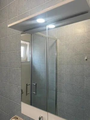 a bathroom with a glass shower with a mirror at Dado Budva Apartment in Budva