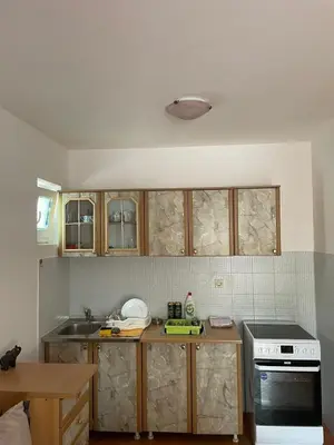 a kitchen with wooden cabinets and a stove at Dado Budva Apartment in Budva
