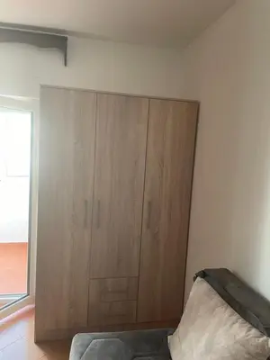 a large wooden cabinet in the corner of a room at Dado Budva Apartment in Budva