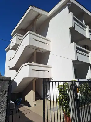 a white building with stairs on the side of it at Apartmani Boskovic in Sutomore