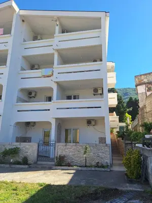 a white apartment building with stairs in front of it at Apartmani Boskovic in Sutomore