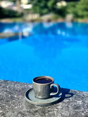 a cup of coffee sitting on a table near the water at Lula Apartments in Ulcinj
