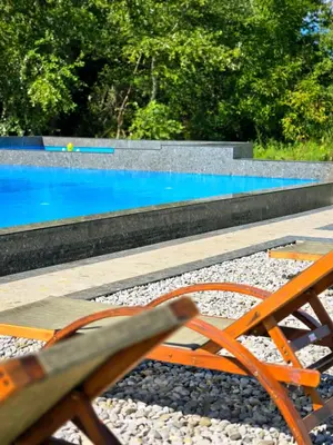 an orange chair sitting next to a swimming pool at Lula Apartments in Ulcinj